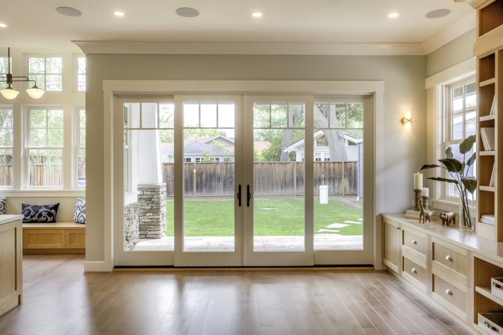Glass patio doors opening to a backyard from a bright room, a project by Symphony Home Improvement.