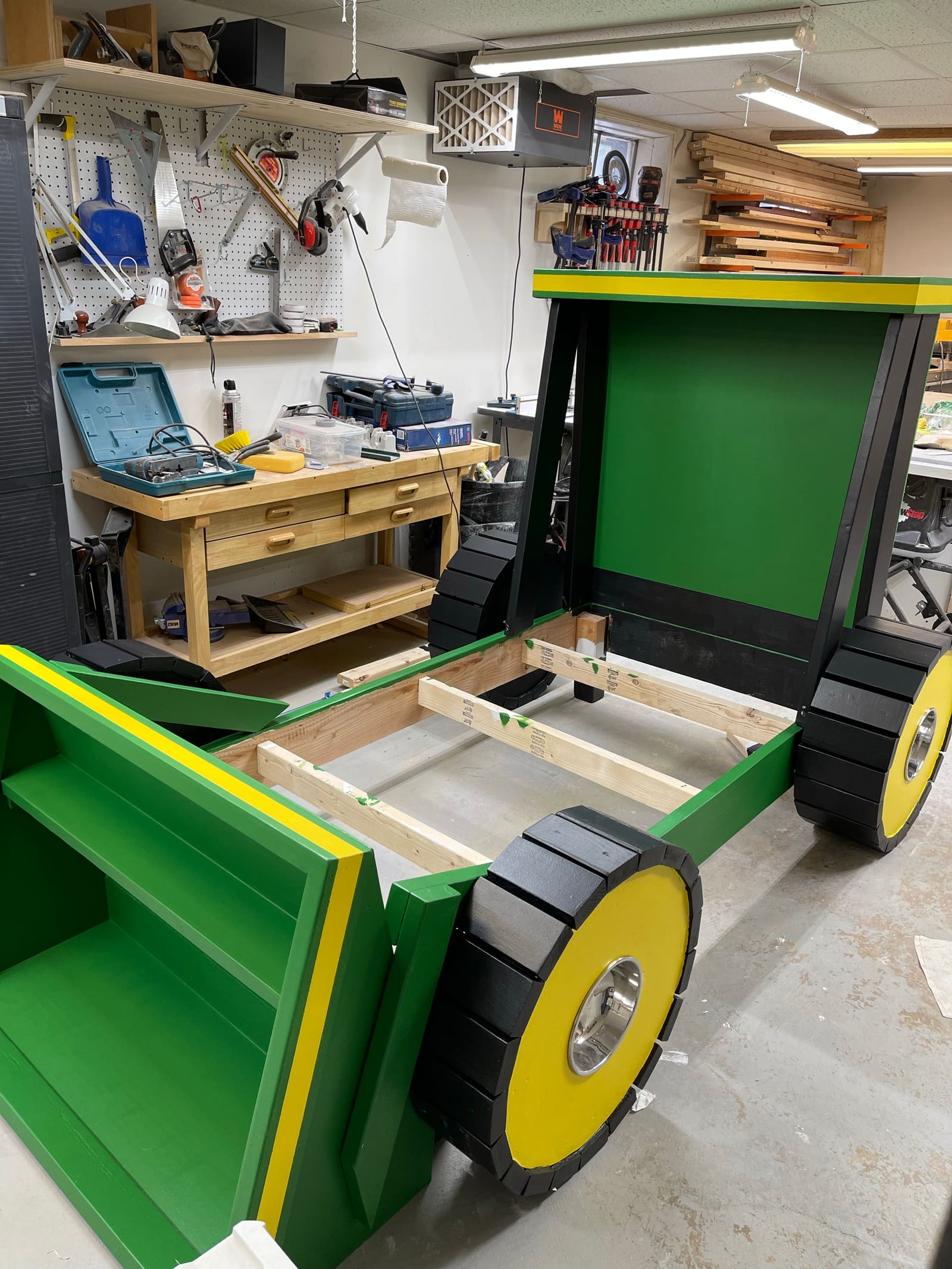 The custom green tractor bed with paint going on in the shop