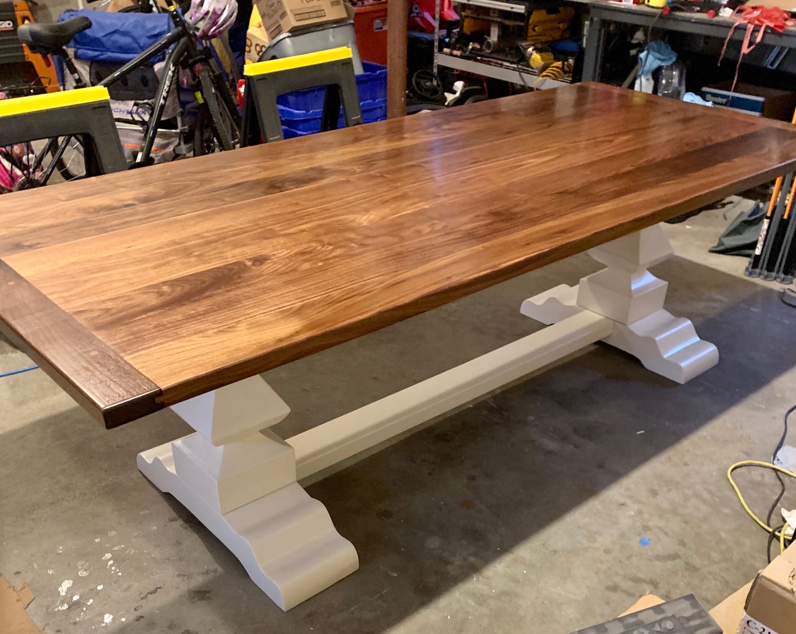 The finished solid walnut table on its custom white pedestals